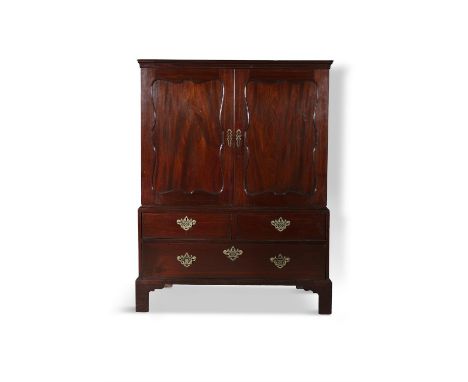 A GEORGE III COMPACT LINEN PRESS of upright rectangular form, with moulded cornice above twin doors with recessed cartouche s