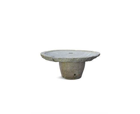 A LARGE ANTIQUE GRANITE CIRCULAR MILLSTONE mounted on a granite base as a table. 176cm diameter, 80cm high**Please note this 