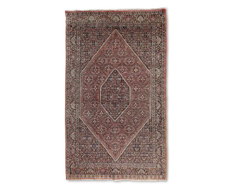 AN OLD BIJAR WOOL RUG N.W IRAN, 243 X 143CMthe central field woven with a small diamond lozenge within a larger diamond lozen