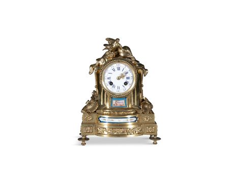 A SMALL 19TH CENTURY FRENCH ORMOLU MANTLE CLOCK,inset with Sevres facet panels, surmounted by an urn, the drum case raised on