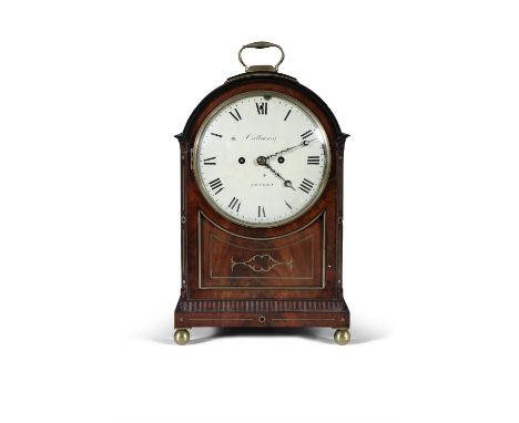 A REGENCY MAHOGANY AND BRASS INLAID BRACKET CLOCK,the arched top with brass carrying handle, over a circular white enamel dia