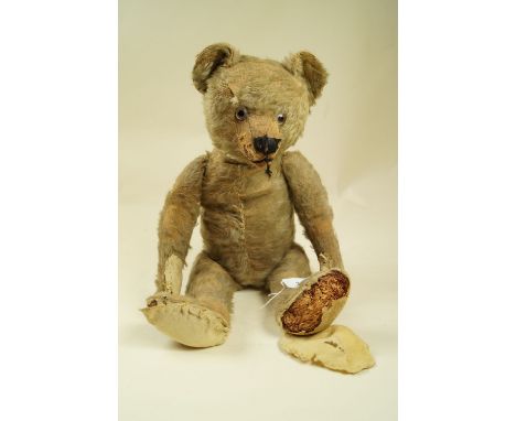 An early 20th century German gold mohair teddy bear with Steiff style humped back, 40cm long, poor condition