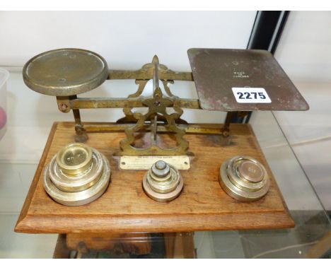 A VINTAGE SET OF BRASS POSTAGE SCALES AND VARIOUS WEIGHTS ON AN OAK BASE.