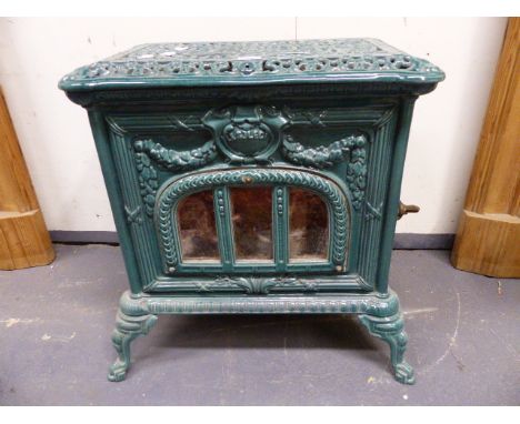 A VINTAGE FRENCH GREEN ENAMEL CAST IRON STOVE WITH PIERCED TOP AND SCROLL LEGS.   H.55 x W.55 x D.42cms.