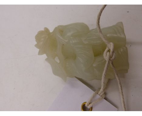 A CHINESE CARVED JADE FIGURAL GROUP WITH FOLIATE SURROUND.   H.5.5cms.