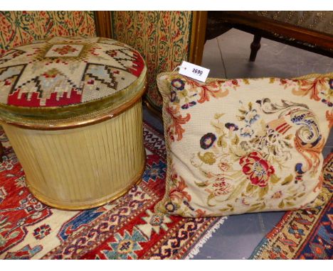 A VICTORIAN GILTWOOD NEEDLEPOINT COVERED OTTOMAN WITH A FLORAL CUSHION COVER OF SIMILAR DATE.
