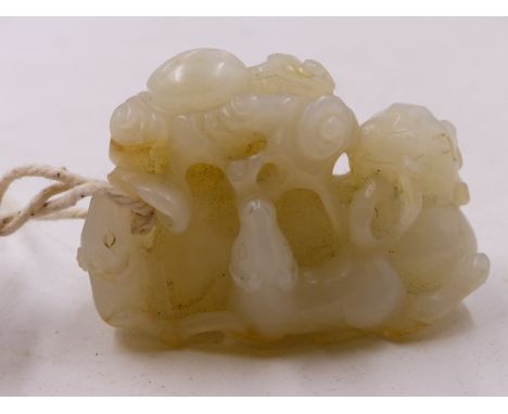 A CHINESE CARVED FIGURAL JADE GROUP OF A RECUMBENT GOAT AND OTHER ANIMALS AMIDST FOLIAGE.   W.6cms.