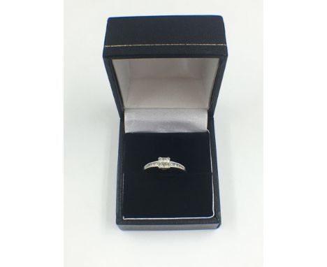AN 18ct WHITE GOLD DIAMOND RING, SET WITH FOUR PRINCESS-CUT DIAMONDS IN A CENTRAL FOUR CLAW SETTING WITH FIVE BRILLIANT-CUT D