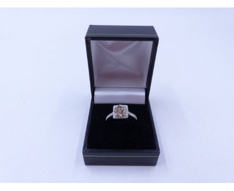 AN 18ct WHITE GOLD BRILLIANT CUT DIAMOND RING SET IN A SQUARE HALO OF DIAMONDS JOINED TO A MICRO DIAMOND SET MOUNT. APPROXIMA