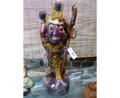A JAVANESE FIGURE OF A DEMON WARRIOR MOUNTED WITH  KRIS WITH WAVY DAMASCENE BLADE CONTIANED IN WOOD SCABBARD
