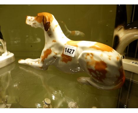 A RUSSIAN PORCELAIN MODEL OF A RECUMBENT HOUND.    H.15cms.  L.29cms.