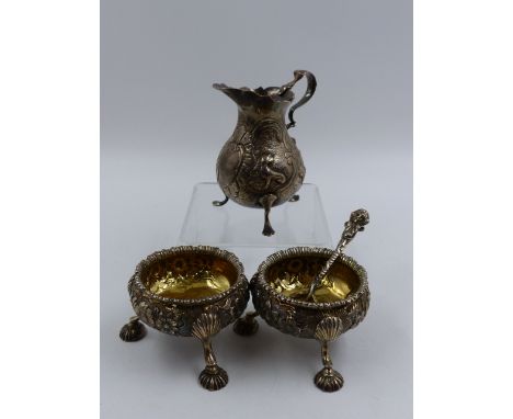 A HALLMARKED SILVER CREAMER, SPOON AND TWO SALTS WITH GILDED INNERS. TOTAL APPROXIMATE WEIGHT 261grms. 