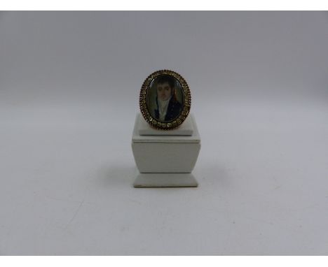 AN ANTIQUE GEORGIAN PAINTED PORTRAIT MINIATURE MOURNING RING. THE OVAL FINELY HAND PAINTED PORTRAIT DEPICTS A YOUNG MAN IN TY