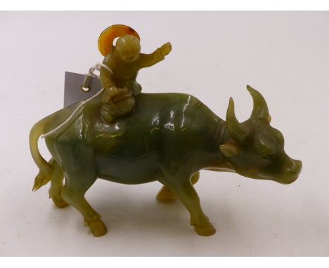 A CHINESE CARVED JADE FIGURAL GROUP OF A BOY RIDING A WATER BUFFALO.   H.14.5cms.