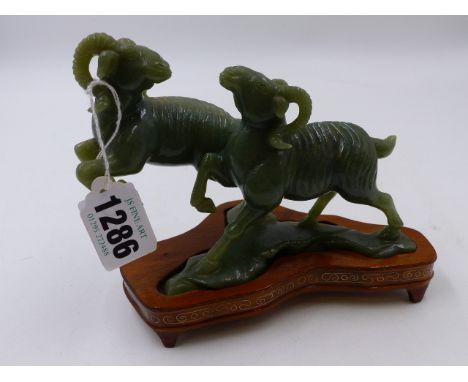 A CHINESE GREEN JADEITE MODEL OF TWO RAMS CAVORTING WITH PLINTH.    L.14cms. (boxed)