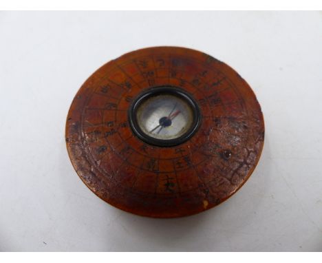 AN UNUSUAL SMALL ORIENTAL LACQUER CASED POCKET COMPASS.   Dia.5cms.