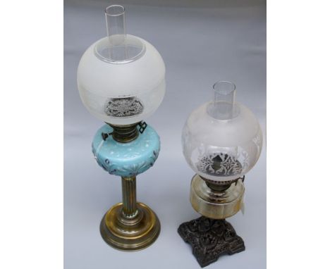 An Edwardian paraffin lamp with blue satin glass reservoir and reeded brass column, together with another lamp having clear r