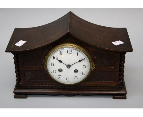 An early 20th century oak mantle clock, the swept barley twist column case enclosing an eight day gong striking movement, fac