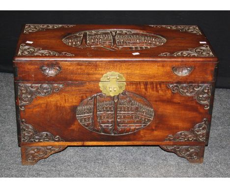 A mid 20th century carved camphor wood trunk, decorated with reserves of pagodas and landscapes, with tray fitted interior, 8