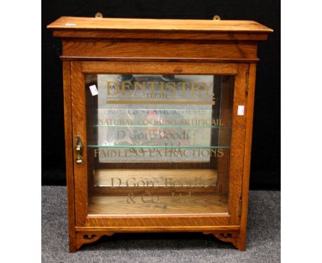 An Edwardian oak wall mounting dentists cabinet, the glazed door named D Gore Boodle and Co. Ltd, enclosing a mirror backed i