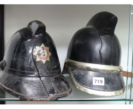 A vintage English hard leather fireman's helmet together with another with nickel mounts