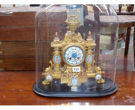 A Victorian gilt brass and porcelain mounted striking mantle clock on an ebonised base with glass dome cover