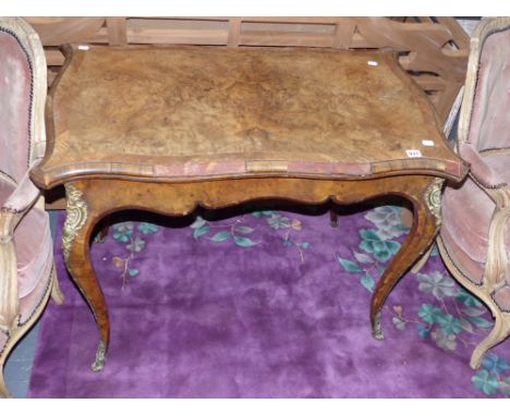 A 19th century walnut serpentine fold over card table on shaped legs with gilt bronze mounts. In the French style