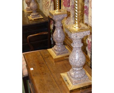 A set of four polished granite ormolu mounted table lamp bases