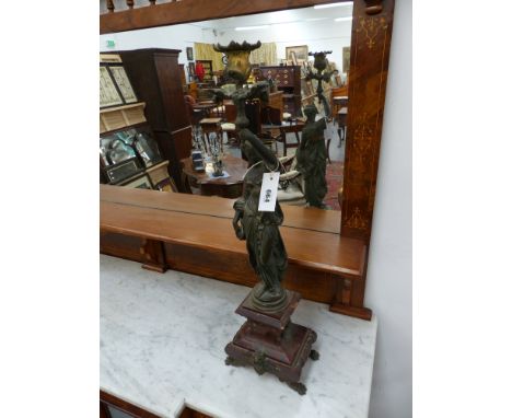 A pair of Antique patinated bronze figural candlesticks on shaped marble bases on paw feet, possibly French