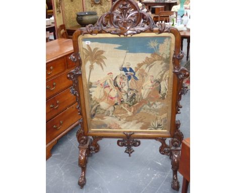 A large and elaborately carved mahogany framed firescreen with fine needlepoint tapestry panel