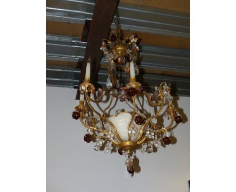 A French gilt metal and alabaster rococo style eight light chandelier hung with prisms and moulded glass fruit
