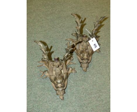A pair of bronze dolphin form wall lights surmounted by shells and rushes