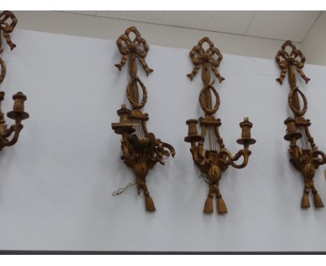 Four carved giltwood twin light sconces and a mirrored pair