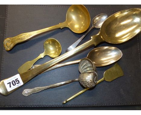 Seven various metal utensils to include a large brass basting spoon, a kings pattern ladle, etc