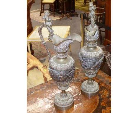 A pair of Antique bronze ewers decorated with Putti and grape vines, possibly French