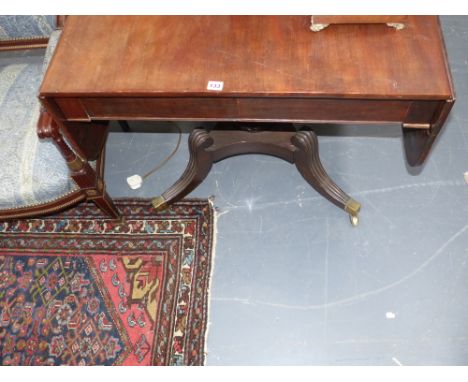 A late Georgian mahogany sofa table on fluted sabre legs stamped Baines & Son, St.Paul's Churchyard