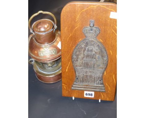 An Antique lead marker decorated with a church surmounted by a crown ,mounted on an oak panel together with a small copper ma