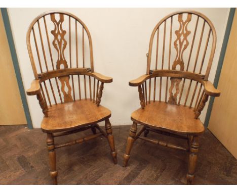 Pair of reproduction oak stick back Windsor elbow chair on cross stretcher bases 