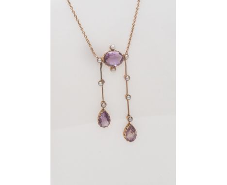 Edwardian negligee pendant necklace, set with amethysts and seed pearls, on a fine gold chain with box link fastening. Unmark