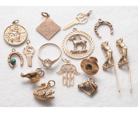 A collection of 9ct gold items to include charms. stick pin and a dress ring. weight 17.9 grams