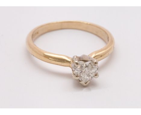 Modern heart shaped diamond solitaire engagement ring, claw set on a yellow 14 karat gold shank. Diamond is approximately 0.4