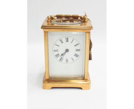 Small French brass carriage clock with key, dial is indistinctly signed Paris - measures 15 cm tall with handle up