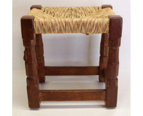 Robert Mouseman Thompson of Kilburn - an oak rectangular stool, rush work top, on octagonal baluster supports with stretchers