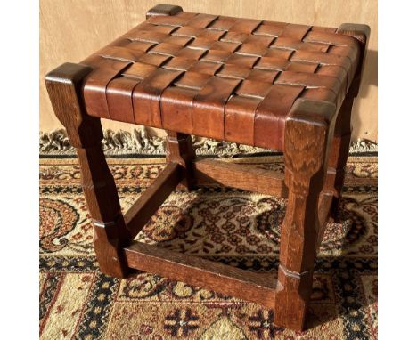 Robert Mouseman Thompson of Kilburn - an oak rectangular stool, plaited leather top on octagonal baluster and block supports 