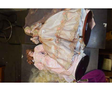 A Franklin Heirloom porcelain doll formed as a lady in pink gown with pearl-effect detail. Height approximately 47cm together