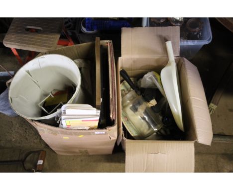 A box containing various pictures and prints, various paperback books, a folding cardboard car windscreen shade, glass storag