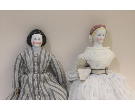 A 19thc china shoulder head doll, with a material body and limbs (27.5cms high), also with a parian doll with china arms and 