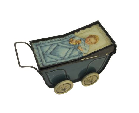 A rare biscuit tin in the form of a pram, with a lithographed lid showing a baby holding a teddy bear, stamped underneath 'Hu