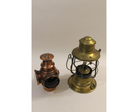 An unusual copper Adlake carbide lamp, with one coloured glass lens and one plain, 22cms high. Also with a brass lantern by P