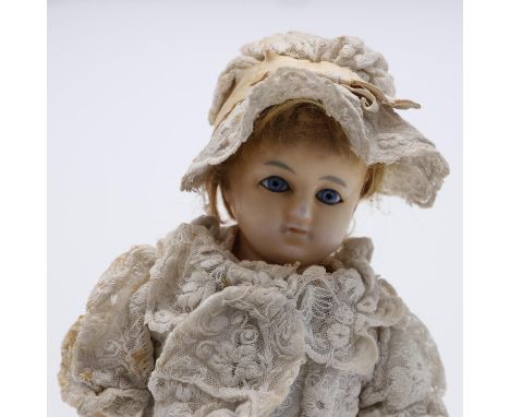 A late 19thc wax head doll, with fixed blue glass eyes and composition limbs including painted shoes. 16 3/4ins (43cms high).